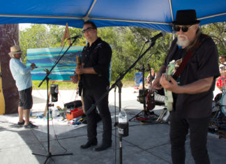 a group of men standing under a blue tent