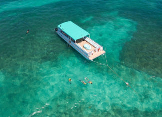 a boat in the ocean with people swimming around