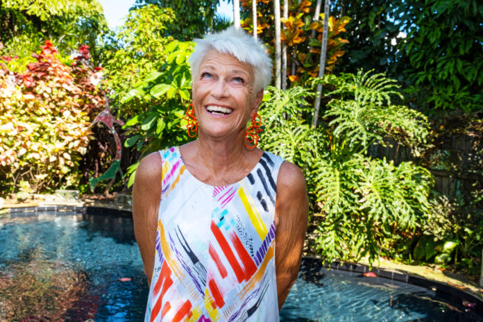 an older woman standing in front of a fountain