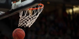a basketball going through the net of a basketball hoop