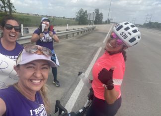 a group of women riding bikes down a street