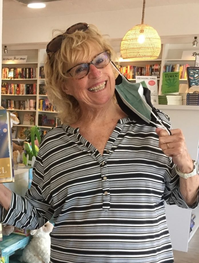 a woman holding up a painting in a store