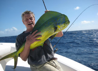 a man on a boat holding a large fish