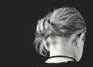 a black and white photo of a woman with her hair in a bun