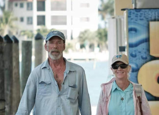 a man and woman walking down a sidewalk holding hands