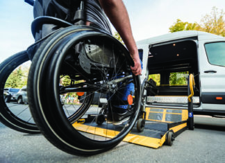 a man in a wheelchair is loading a van