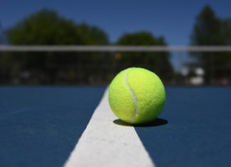 a tennis ball sitting on the edge of a tennis court