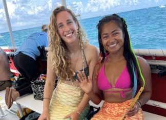two women in bikinis sitting on a boat