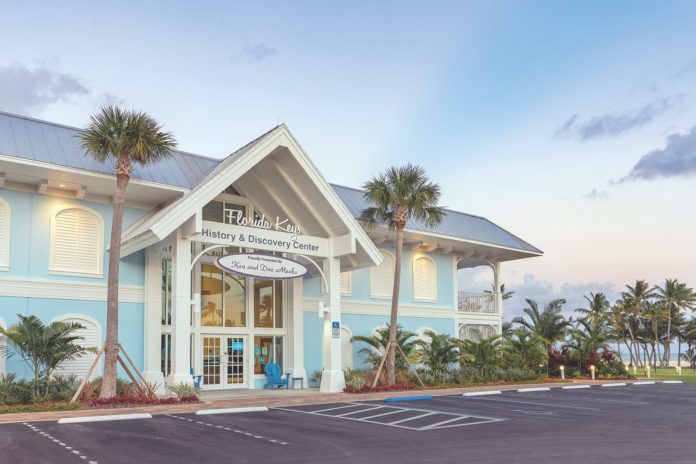 a blue and white building with palm trees in front of it