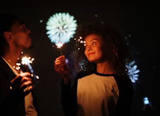 a man and a woman holding sparklers in their hands