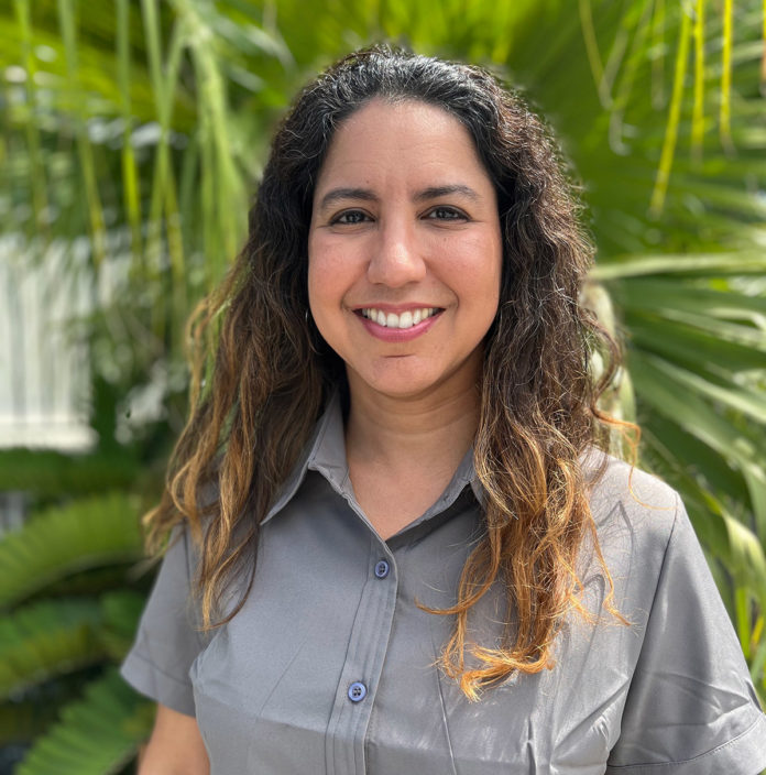 a woman standing in front of a palm tree