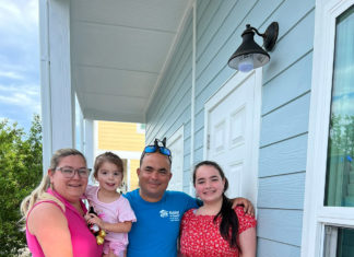 a family standing on the porch of a house