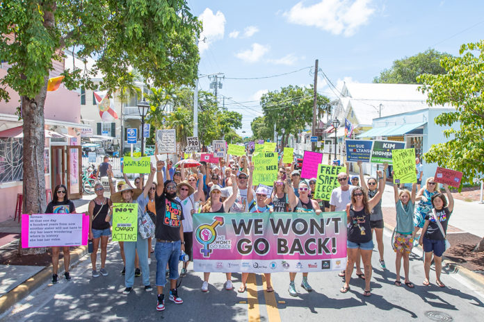 a group of people holding signs on the street
