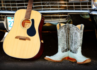 a pair of cowboy boots sitting next to a guitar