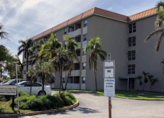 an apartment building with palm trees in front of it