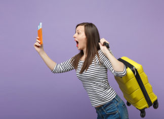 a woman holding a yellow backpack and a cell phone