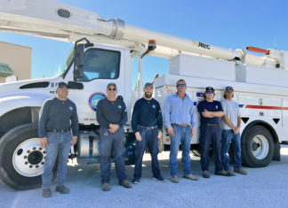 a group of men standing in front of a white truck