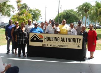 a group of people standing in front of a housing authority sign