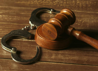 a wooden gaven and handcuffs on a wooden table