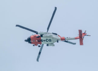 a red and white helicopter flying in the sky
