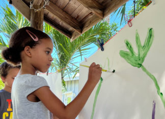 a young girl is drawing on a white board