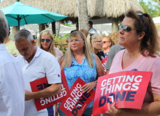 a group of people standing around each other holding signs