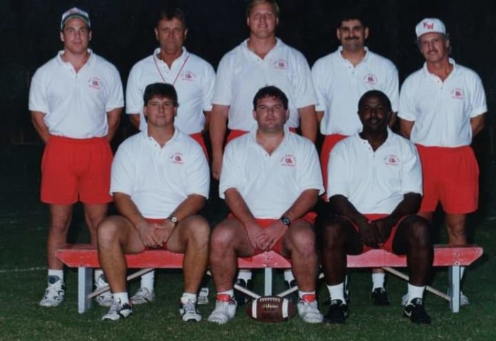 a group of men sitting on top of a bench