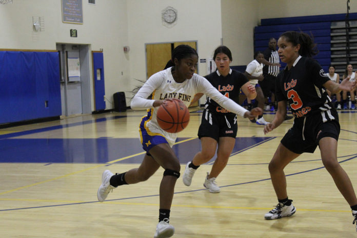 a group of young women playing a game of basketball