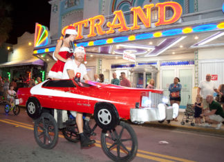 a couple of people riding on the back of a red car