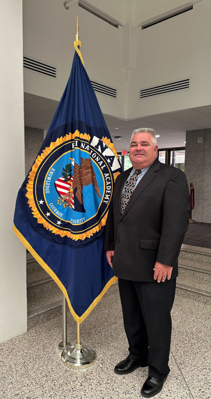 a man in a suit standing next to a flag