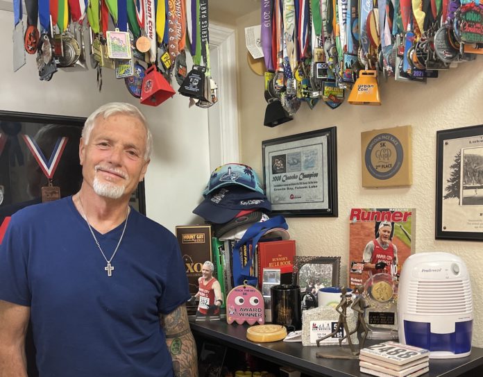 a man standing in front of a table filled with medals