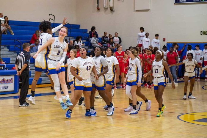 a group of young women playing a game of basketball