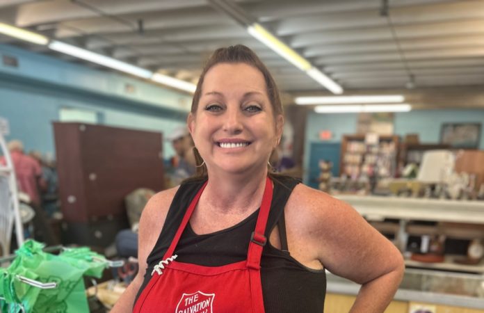 a woman in a red apron standing in a store