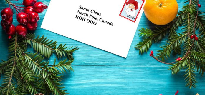 a letter to santa claus on a blue wooden table