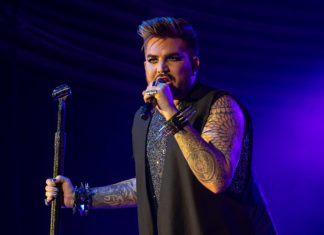 a man with tattoos on his arm holding a microphone