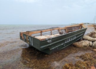 a boat sitting on top of a rocky beach