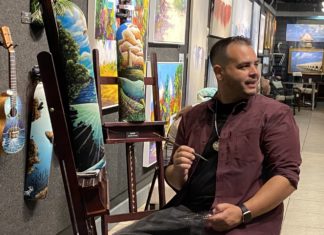 a man sitting on a chair in front of paintings