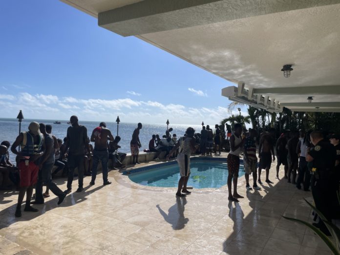 a group of people standing around a swimming pool