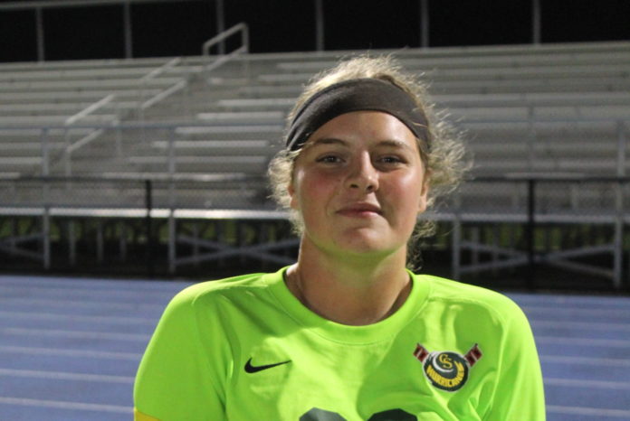 Katelyn Gilman 2 a woman in a green shirt is holding a tennis racket