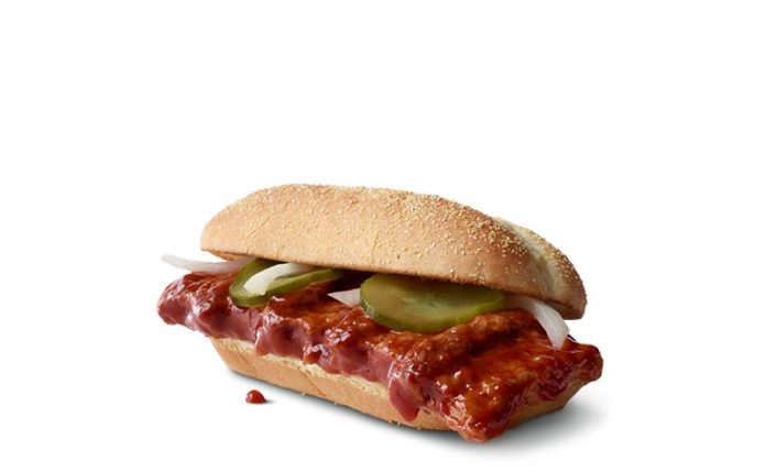 a sandwich with meat and pickles on a bun