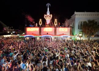a crowd of people standing around a carnival at night