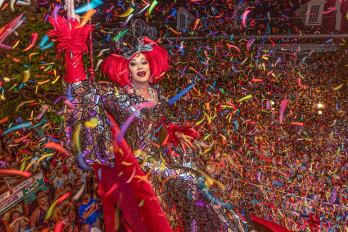a woman in a costume surrounded by confetti and streamers
