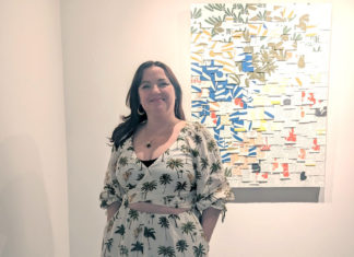 a woman standing in front of a painting