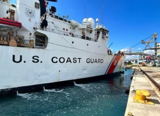 a large white boat in the water near a dock