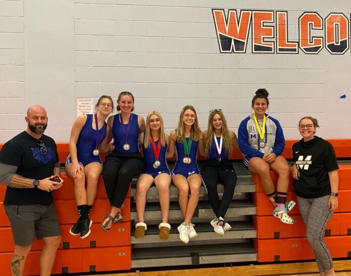 a group of people sitting on top of a bleachers