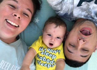 a couple of people that are laying down with a baby