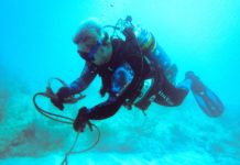 a man in a diving suit is holding a rope