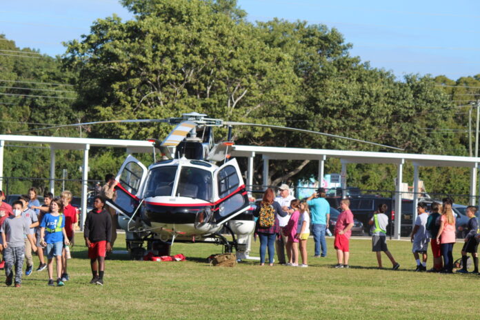 a group of people standing around a helicopter