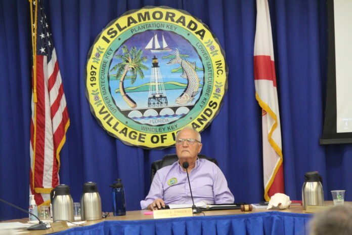Mayor Buddy Pinder a man sitting at a table with a microphone in front of him