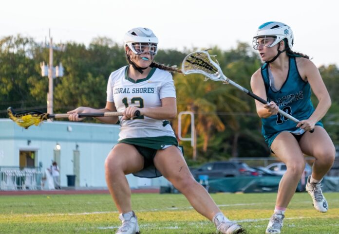 a couple of women playing a game of lacrosse